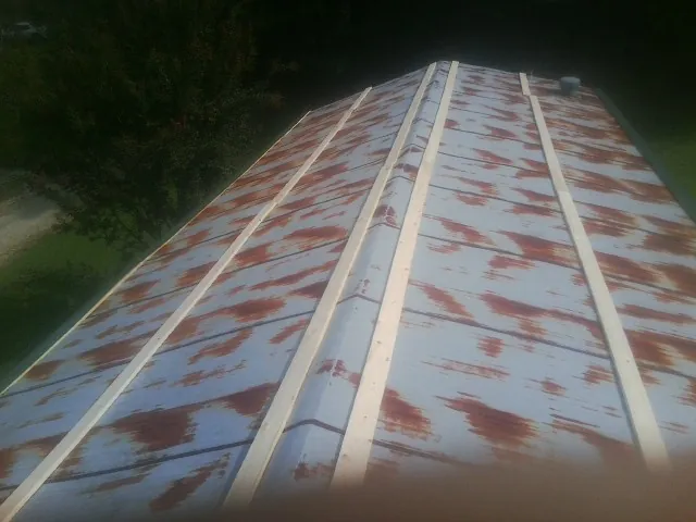 Rusted metal roof panels with new wood purlins before replacement — Storm Damage Roof Repair in Palmer Lake by Roofing Brothers